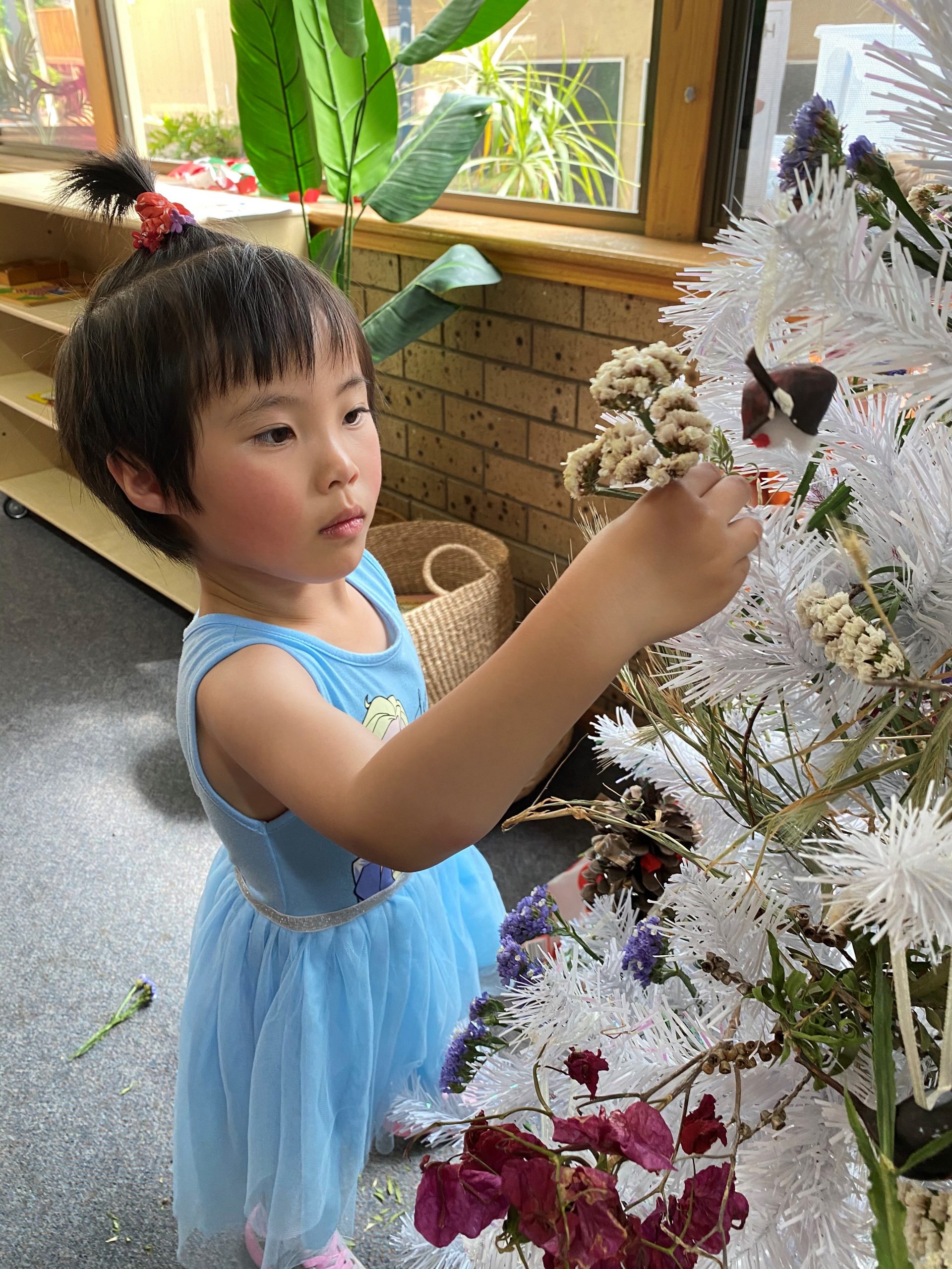 CHRISTMAS SPIRIT: Anne at Concordia Kindergarten reflects on the meaning of Christmas while decorating a tree as part of the ac.care Murraylands Communities for Children initiative.