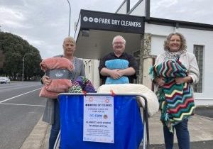 BUSINESS BACKS APPEAL: ac.care homelessness service senior manager Trish Spark, Triple M Limestone Coast breakfast announcer Ewan Grant and Park Dry Cleaners owner Michele Colbert hold some of the new and handmade blankets donated at the Commercial Street West business.